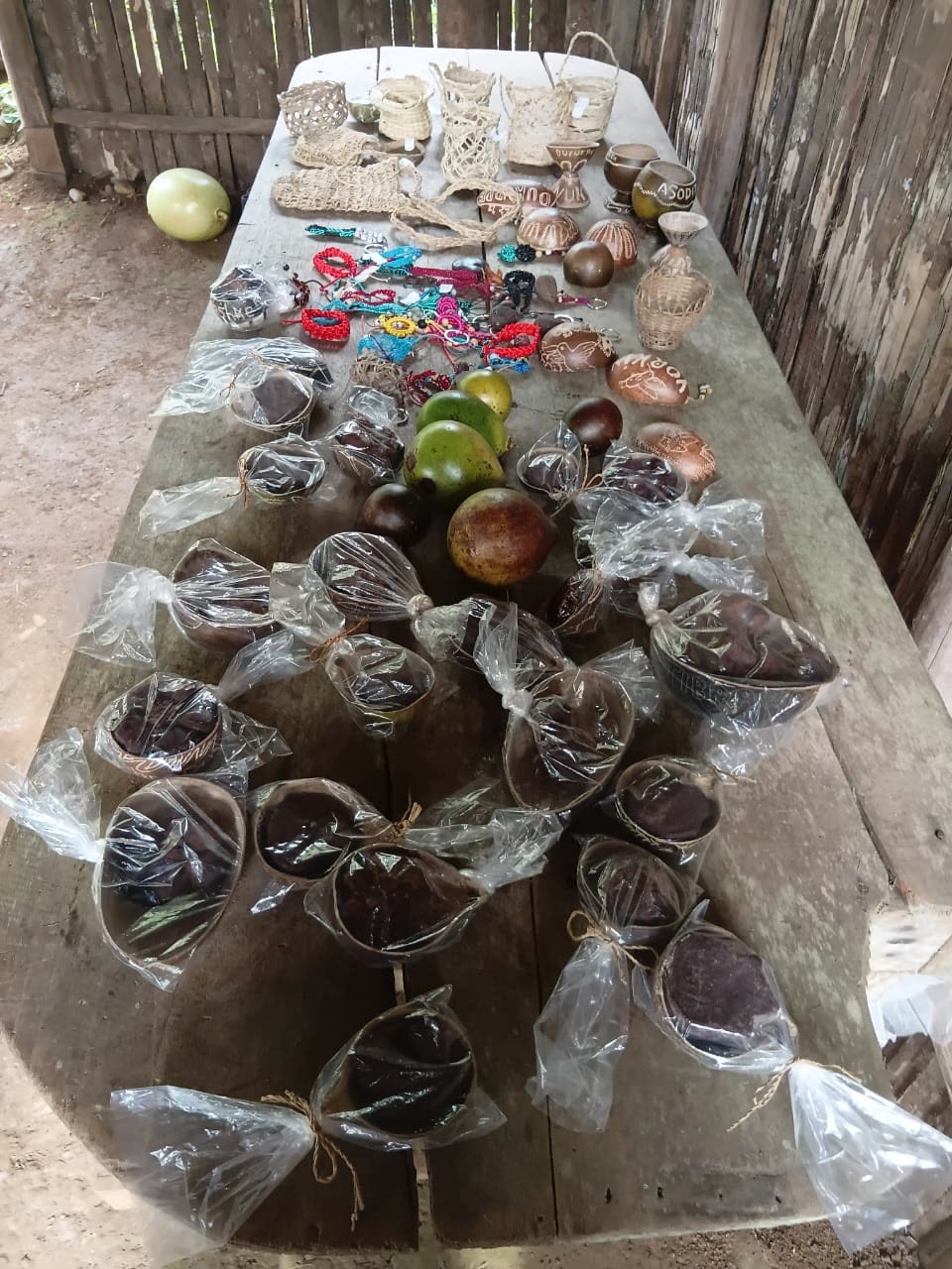 Mesa con artesanía en jícaro, canastas, pulseras y tabletas de cacao